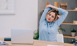 Businesswoman Stretching Shoulders At Workplace In Office